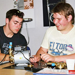 closeup of robbie and james working on a pump